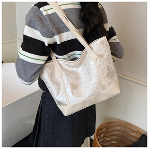 Détail du sac cabas en cuir crème avec imprimés papillons et rivets argentés brillants