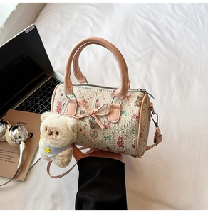 Detail of pink Boston bag with bear patterns, bow charm and plush bear keychain