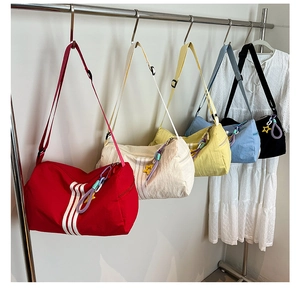 Detailed view of colorful cylinder gym bags with striped design and star pendants