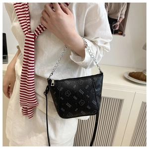 Detail of black textured bucket bag with printed bear motifs and silver chain strap