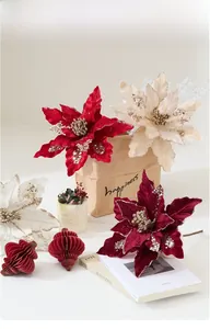Close-up of velvet poinsettia Christmas flowers with glitter on festive backdrop