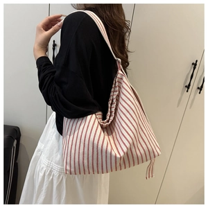 Detail of red and white striped canvas tote bag showing durable texture and large capacity