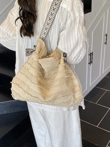 Große beige Strandtasche aus Stroh mit Fransen und ethnisch gewebtem Schultergurt