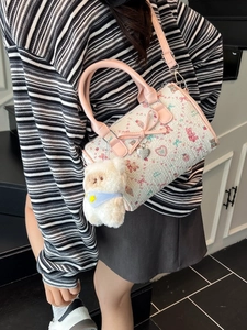 Floral Boston bag with pink leather straps and cute bear charm shown on a model