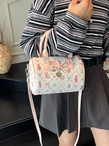 Cute white Boston bag with pink trim featuring cartoon prints and a large bow