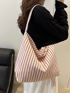 Grand sac cabas en toile à rayures rouges et blanches porté par un mannequin
