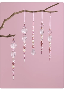 Detailed view of 5 pink acrylic bead pendants with ribbons hanging on a branch