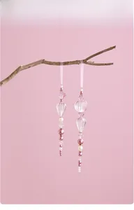 Detailed view of pink acrylic crystal beaded ornaments hanging on a dry wooden branch