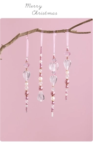 Pink acrylic crystal Christmas ornaments hanging on branches with Merry Christmas text