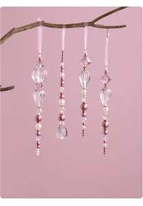 Detail of pink acrylic crystal Christmas ornaments with pearls hanging on wooden branches