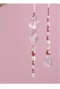 Close-up of pink acrylic crystal beads and pearls ornaments with elegant ribbon ties