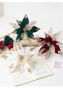 Macro detail of artificial poinsettia with velvet petals and gold sequins for Christmas