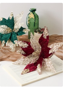 Detail of red and gold glitter poinsettia flower on a vintage book for Christmas decor
