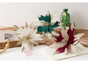 Close-up of velvet poinsettia flowers with gold sequins for Christmas decoration