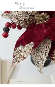 Close-up of red velvet artificial Christmas flower with gold glitter edges and berries