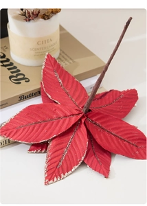 Detail of a red Christmas poinsettia with gold glitter edges and realistic petal texture