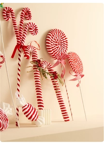 Detail of red and white velvet candy cane ornaments with bows and pine needles