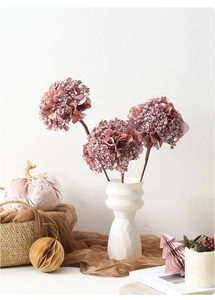 Hortensias pailletés roses dans un vase en céramique blanc pour décor de table