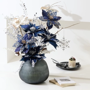 Dark blue and silver Poinsettia artificial flower arrangement in a grey ribbed glass vase