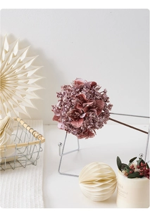 Vue détaillée d'une fleur d'hortensia rose avec des accents pailletés brillants.