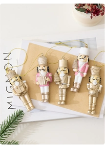 Set of five pink and gold resin nutcracker soldier ornaments with golden hanging loops
