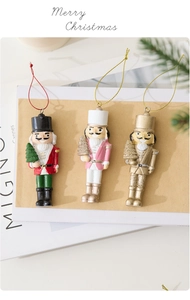 Detailed view of three resin Nutcracker soldier ornaments with mini Christmas trees