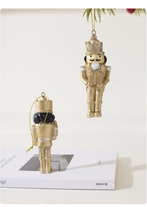 Detail of golden nutcracker Christmas ornaments with glitter accents on pine branches
