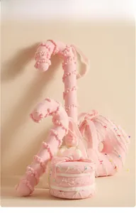 Detailed view of pink candy and donut plush ornaments with festive bows and beads