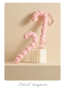 Detailed view of pink candy cane Christmas ornaments with ribbon and dotted texture