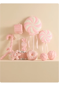 Close-up of pink and white lollipop and donut Christmas tree ornaments with glitter