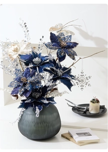 Detailed view of dark blue and silver poinsettia flowers with beads in a glass vase