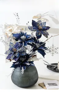 Deep blue and cream artificial poinsettias with glitter in a textured glass vase