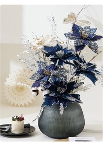 Dark blue and white Christmas poinsettia arrangement with sequins in a grey striped vase