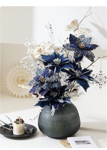 Blue and cream poinsettia Christmas floral arrangement in a ribbed grey glass vase