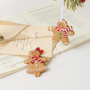 Γοητευτικά διακοσμητικά ζευγάρι gingerbread κρεμασμένα σε κλαδιά χριστουγεννιάτικου δέντρου