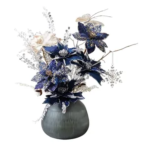 Navy blue artificial poinsettia floral arrangement in a frosted glass vase for Christmas