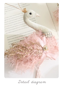 Close-up of pink velvet swan ornament with golden crown and sparkling rhinestone detail