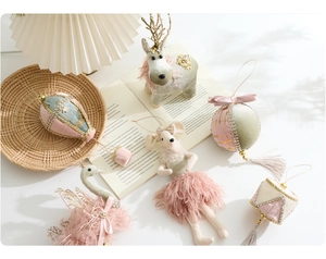 Close-up of velvet Christmas ornaments featuring plush swans and ballet mice decorations
