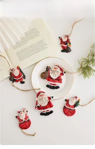 Detailed view of hand-painted resin Santa ornaments with festive ropes for Christmas tree