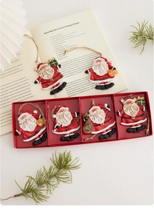 Close-up of six retro Santa Claus resin ornaments with natural jute strings in a red gift box