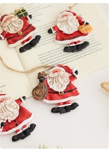 Detailed view of four festive resin Santa Claus ornaments with gift boxes and candy canes
