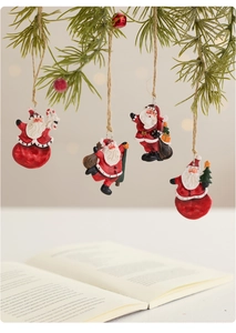 Close-up of four vintage hand-painted resin Santa ornaments hanging on pine branches