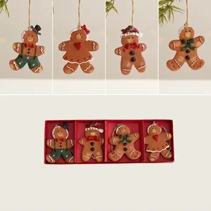 Detailed view of 4 resin gingerbread man ornaments in a festive red display box