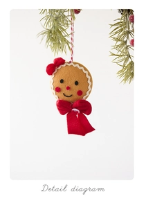 Detailed view of handmade gingerbread man felt ornament with red bow on Christmas tree