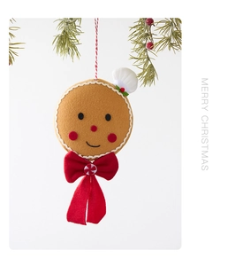 Macro detail of gingerbread man felt ornament with red bow and chef hat for Christmas