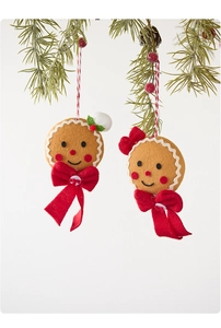 Close-up of gingerbread man felt ornaments with red bows hanging on a Christmas tree branch