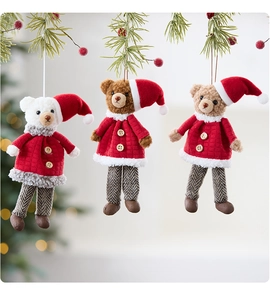 Detailansicht von drei Plüschbär-Weihnachtsanhängern in roten Outfits am Tannenbaum