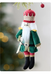 Detail of plush nutcracker soldier ornament with velvet uniform on a Christmas tree