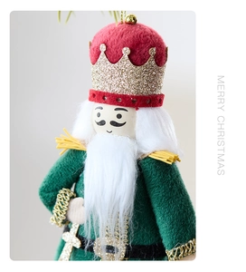 Close-up of velvet nutcracker king ornament with red crown and gold hanging string
