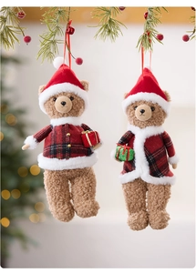 Detail of plush Christmas teddy bear ornaments hanging on pine branches with red berries